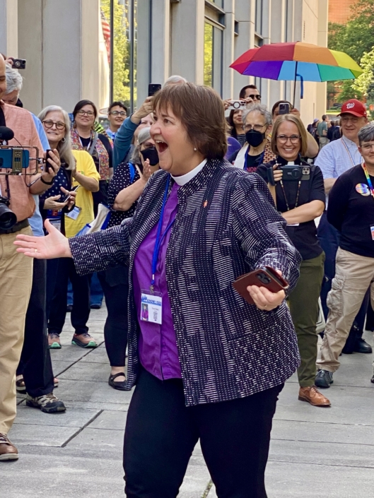 Biskop Karen Oliveto taler en en stor gruppe glade LGBTQ-aktivister